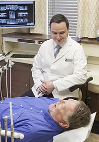 Dr. Pellegrino going over x-rays with a patient in a treatment room.