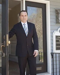 Dr. Christopher Pellegrino holding the front door open at Hingham Dental Associates.