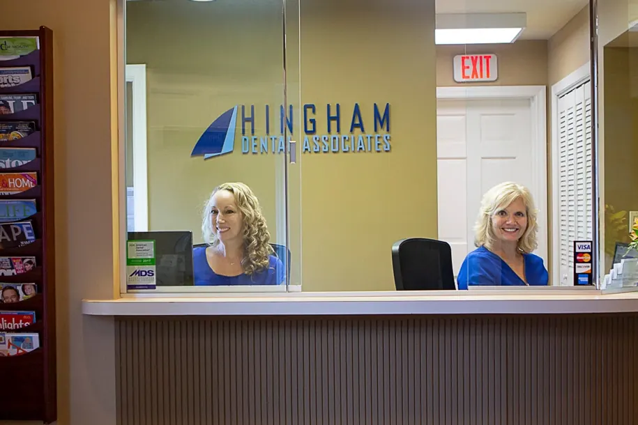 The front desk at Hingham Dental Associates, with the sail logo on the glass.
